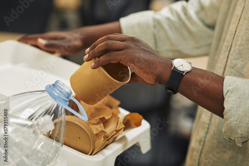 Obraz na plátně Close up of unrecognizable African-American man putting paper cup into waste sor