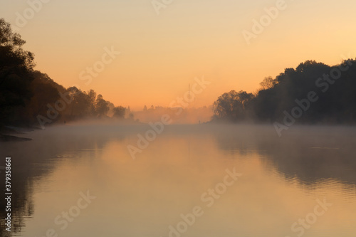 Men fishing in river with fly rod during summer morning. Beautiful fog.