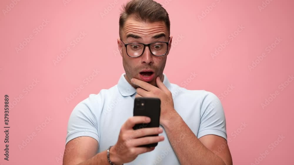 young handsome casual guy scratching his face while looking at his phone, being shocked and angry, slapping his face and waving his head young handsome casual guy scratching his face while looking at his phone, being shocked and angry, slapping his face and waving his head