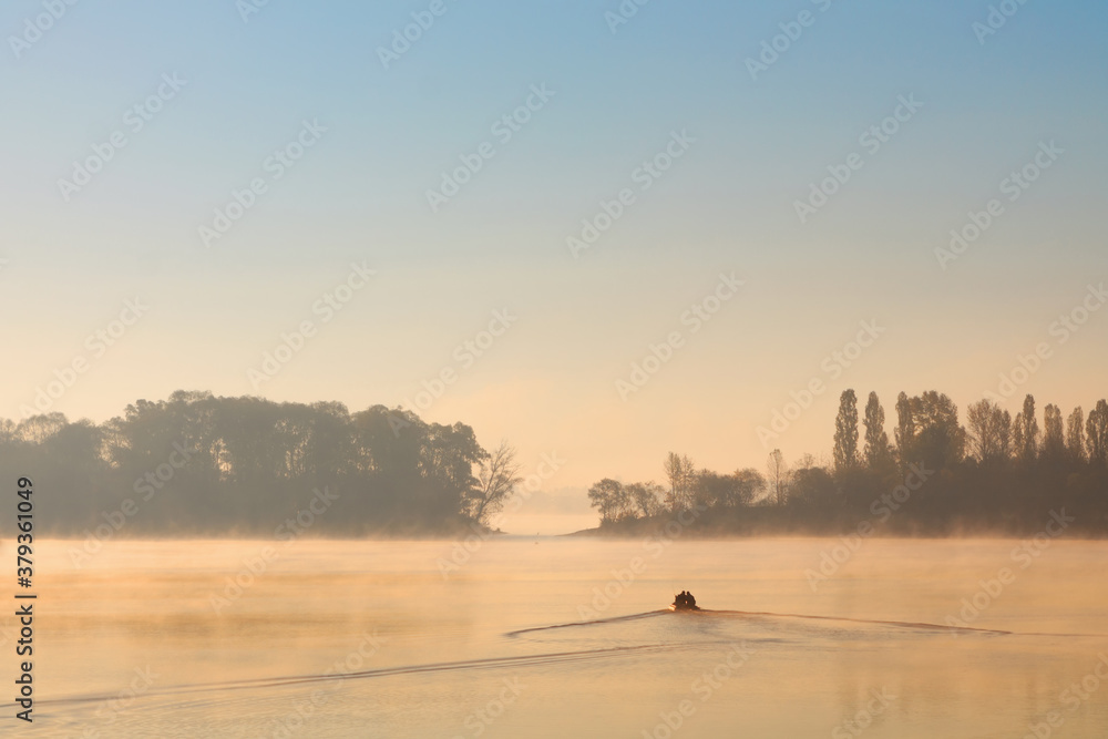 Early morning sunrise, boating on the lake in a huge fog