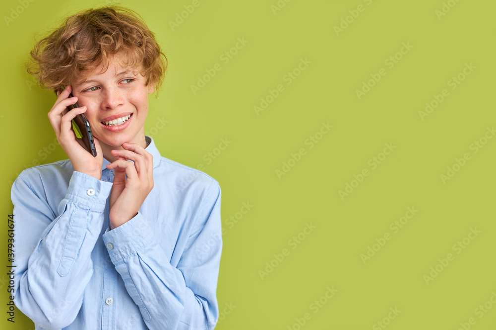 caucasian blonde boy talk on phone with girlfriend, has some flirt with someone, smile, teenager love concept. isolated green background caucasian blonde boy talk on phone with girlfriend, has some flirt with someone, smile, teenager love concept. isolated green background