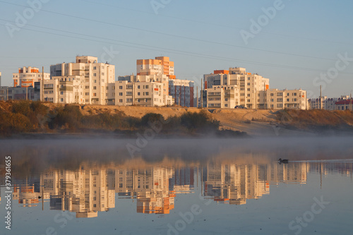 Multi-storey city houses near a lake with fog Gomel, BELARUS photo