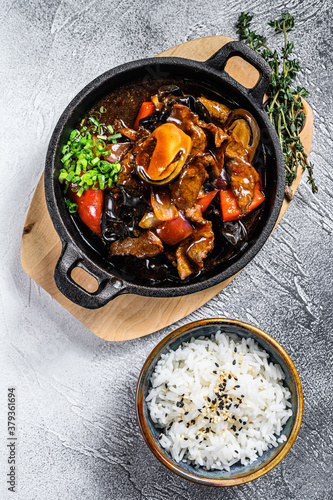 Beef meat in teriyaki sauce with rice. White background. Top view