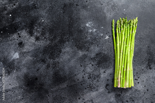 banches of fresh green asparagus. Black background. Top view. Copy space