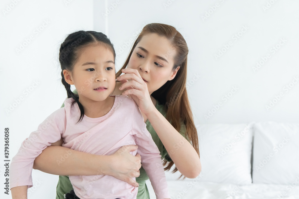 asian caucasian family, mother and daughter embrace smiling in bedroom. asian caucasian family, mother and daughter embrace smiling in bedroom.
