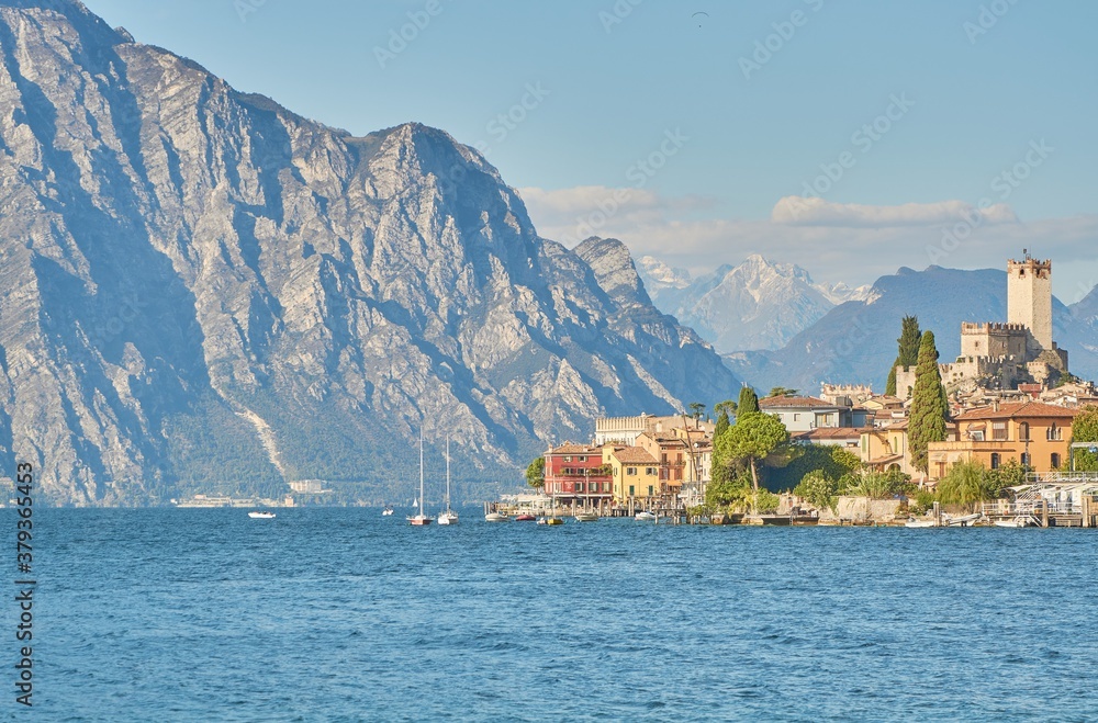Sunset at the Lake Garda with huge cliffs and Malcesine in the background.