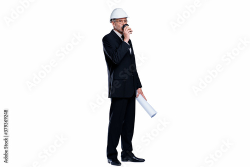 Successful senior man, professional engineer and designer wear a white safety helmet with project paper, and cup coffee stay isolated on white background