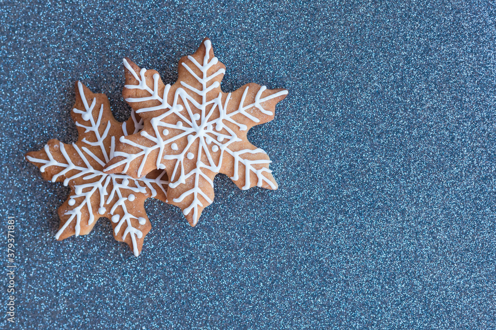 Christmas blue decorations gingerbread snowflake cake cookies biscuits on blue background. Flat lay, top view, copy space Christmas blue decorations gingerbread snowflake cake cookies biscuits on blue background. Flat lay, top view, copy space