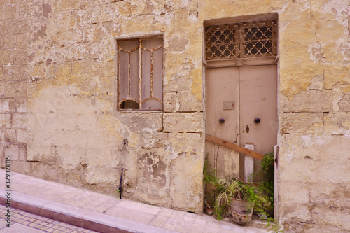Doors and window to abandoned house with shabby wall