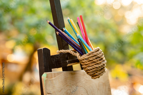 Colored pencils tied with a rope in garden for kid zone photo