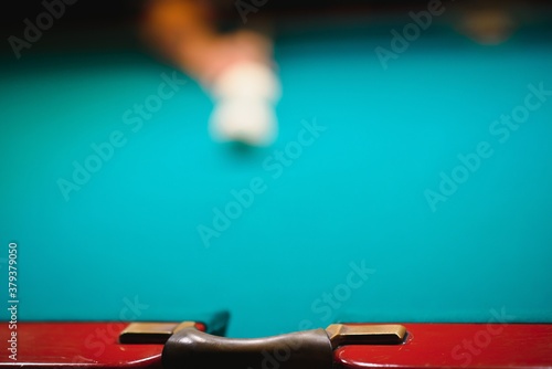 game of billiards the hand of a man with a billiard cue aims at a billiard ball