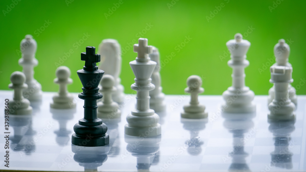 Wooden chess pieces in board game with green background Wooden chess pieces in board game with green background
