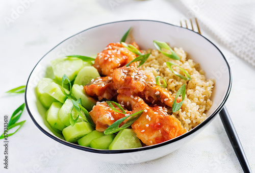 Fish fillet cooked in tomato sauce with bulgur and cucumber on a plate on a light background. Healthy eating concept. Easy cooking.