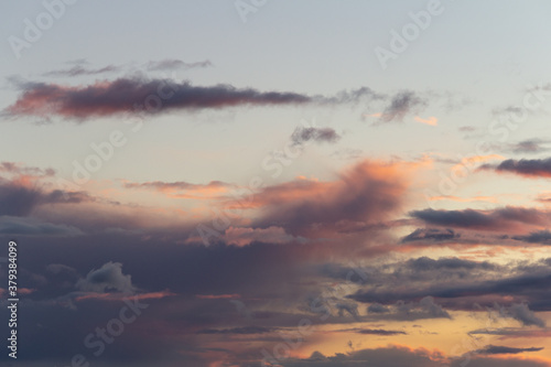 Evening sky with rain clouds in orange-pink sunset light