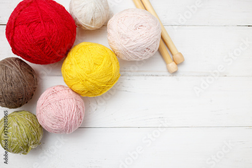 Knitting wool and crochet hook on white wooden background. Top view, flat lay, copy space. Female hobby. Frame of yarn.