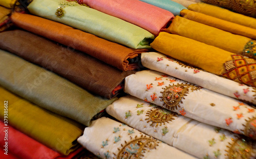 View of Indian woman dress sarees or saris rolled and stacked in display of shop