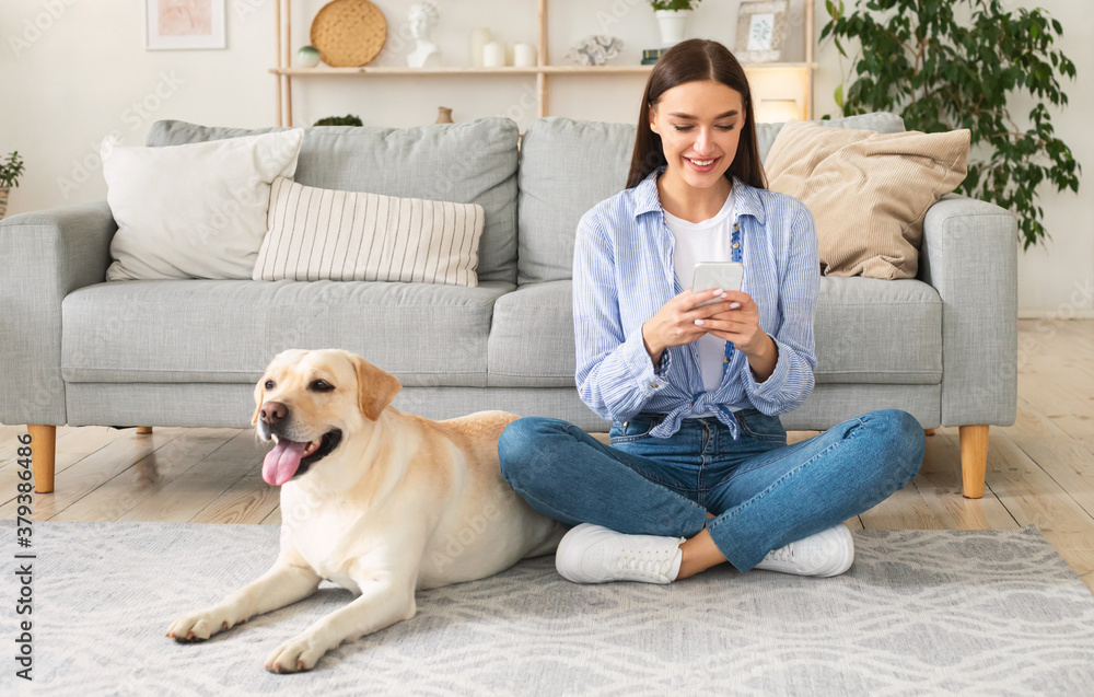 Portrait of young lady with her dog using mobile phone Portrait of young lady with her dog using mobile phone