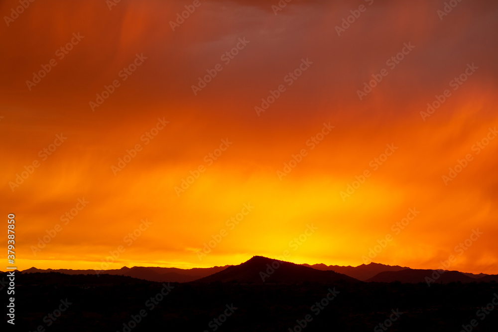 A dramatic cloudy sunset in the desert of Arizona with mountains.
