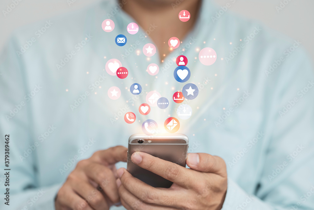 Social media and marketing concept, Businessman holding white smartphone and using colourful social media icons.