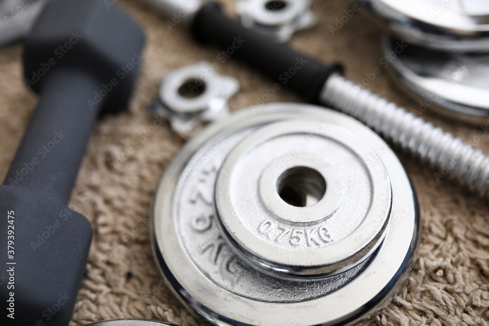 Pile of shiny chrome dumbbells disks lying around grip Pile of shiny chrome dumbbells disks lying around grip