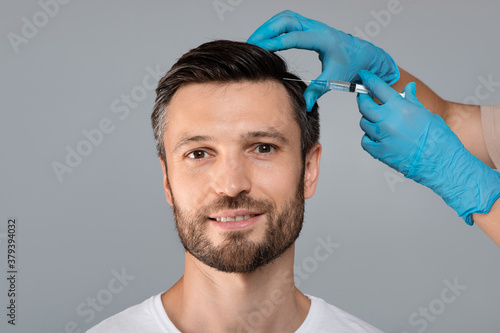 Handsome man having hair treatment at salon photo