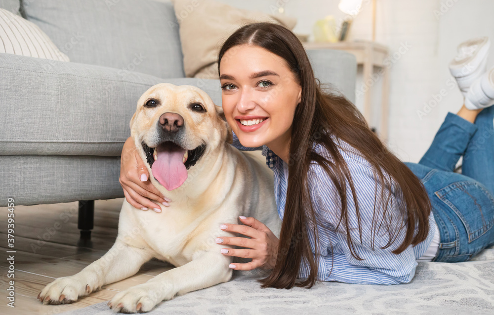 Young happy lady with her labrador lying on floor Young happy lady with her labrador lying on floor