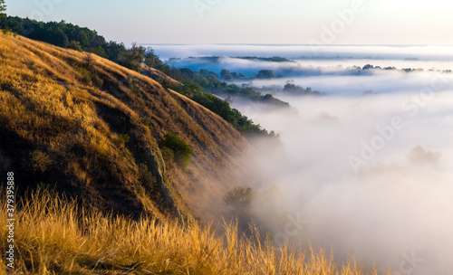 Fototapeta Naklejka Na Ścianę i Meble -  Morning foggy valley with river, hills and withered grass