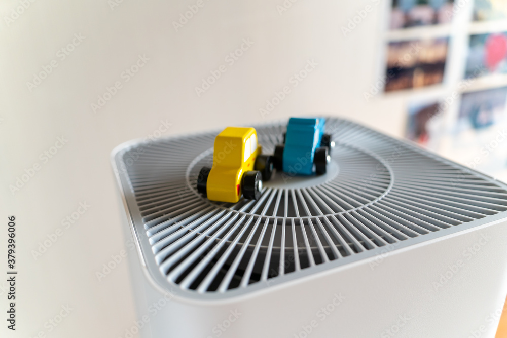 An air purifier with a toy car placed nearby. eco-friendly car concept An air purifier with a toy car placed nearby. eco-friendly car concept
