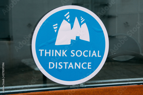 Photo Closeup shot of a blue sticker about social distance in Euston railway station,