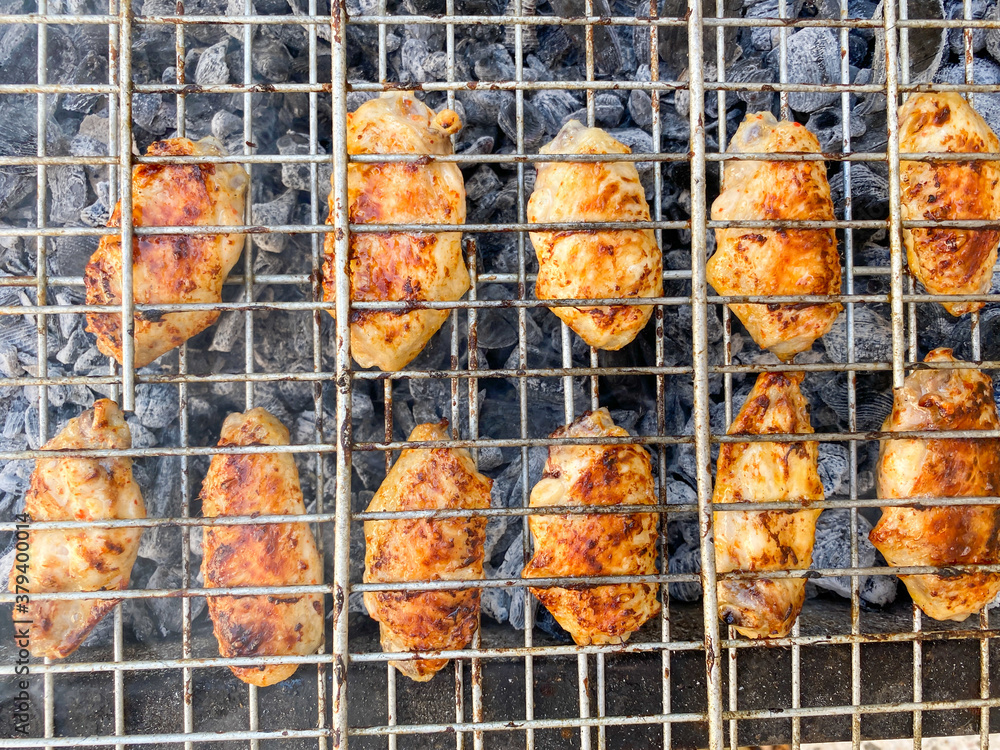 Delicious Grilled chicken on barbecue. Chicken wings on the mangal in nature. Picnic.