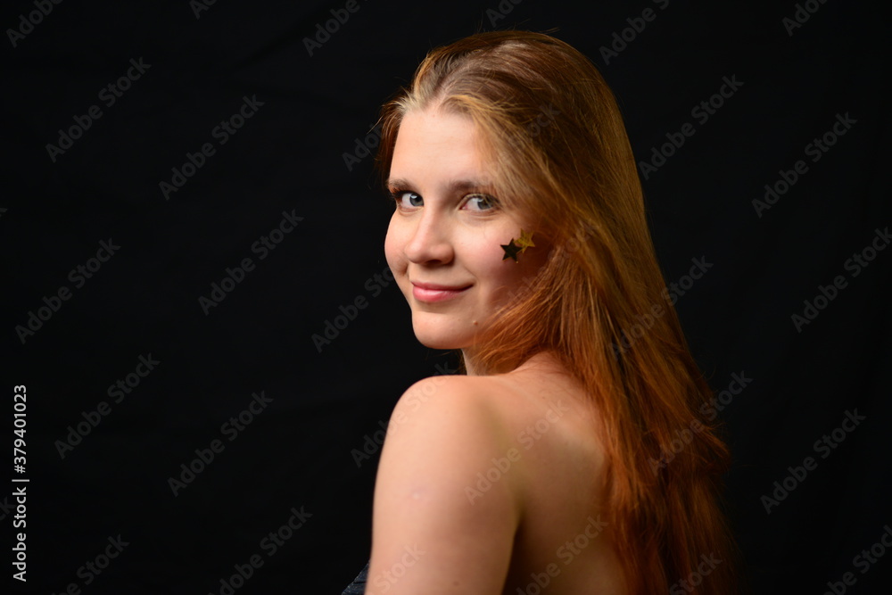 Beautiful young woman face close up portrait in studio on black. various emotions. foil stars glued to the face