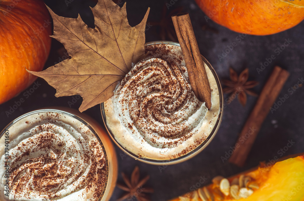 Pumpkin latte drink. Autumn coffee with spicy pumpkin flavor and cream on a dark background. Seasonal Fall Drinks for Halloween and Thanksgiving Pumpkin latte drink. Autumn coffee with spicy pumpkin flavor and cream on a dark background. Seasonal Fall Drinks for Halloween and Thanksgiving