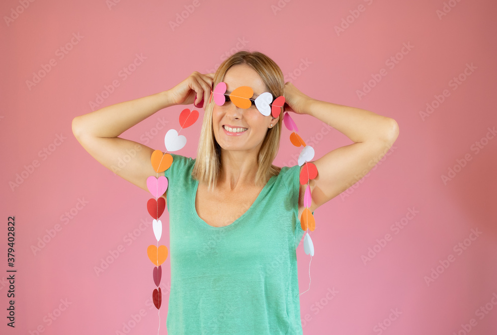 Woman wearing a ribbon of hearts over her eyes Woman wearing a ribbon of hearts over her eyes