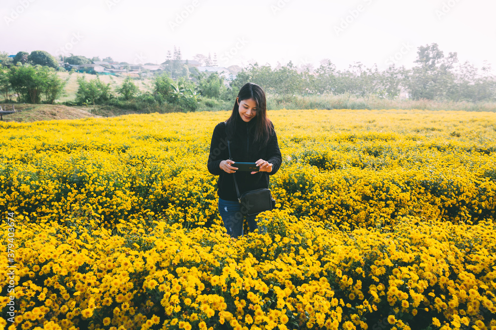 Traveler asian woman selfie with mobile phone in flower garden with fog in Thailand Traveler asian woman selfie with mobile phone in flower garden with fog in Thailand