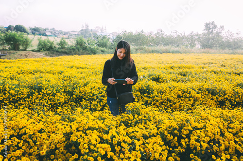 Traveler asian woman selfie with mobile phone in flower garden with fog in Thailand © Peera