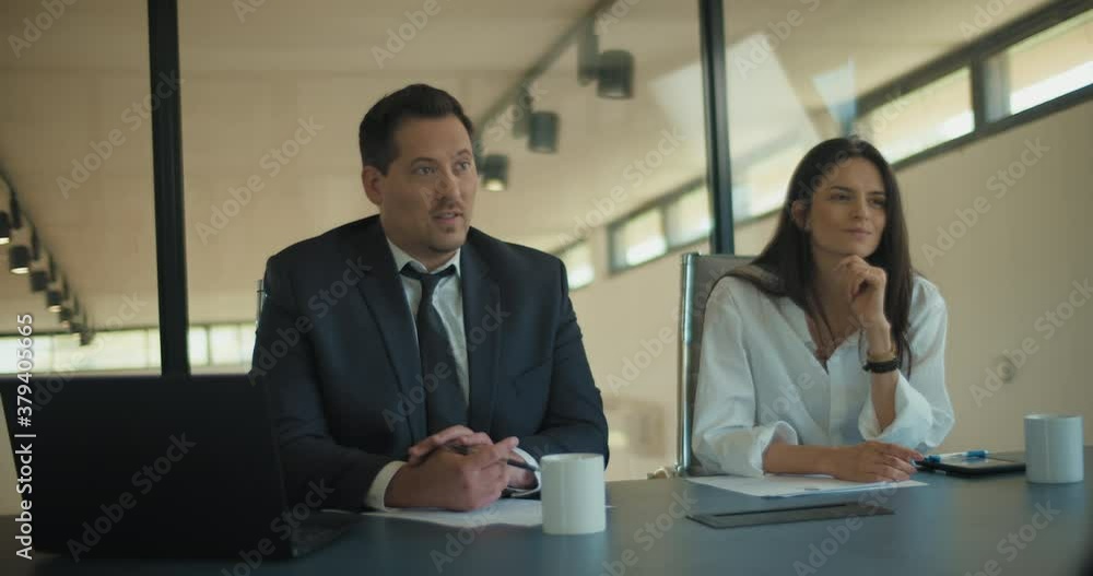 Two people in suits discuss a business project strategy with their colleagues in the office meeting room. Medium shot, slow motion. Two people in suits discuss a business project strategy with their colleagues in the office meeting room. Medium shot, slow motion.
