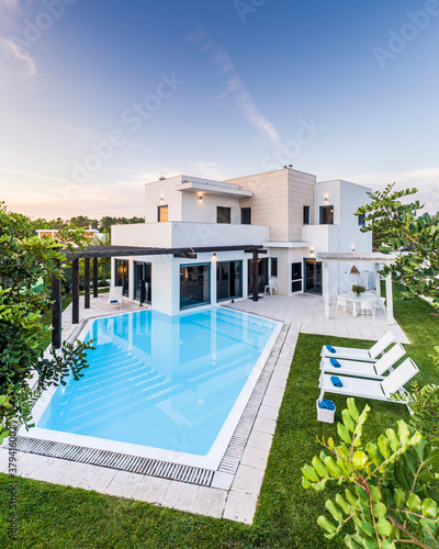 Modern house with garden swimming pool and wooden pergula photo
