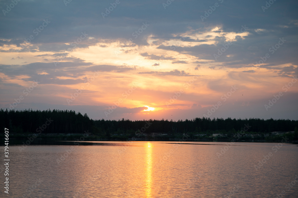 Sunset over a forest lake. Beautiful view.