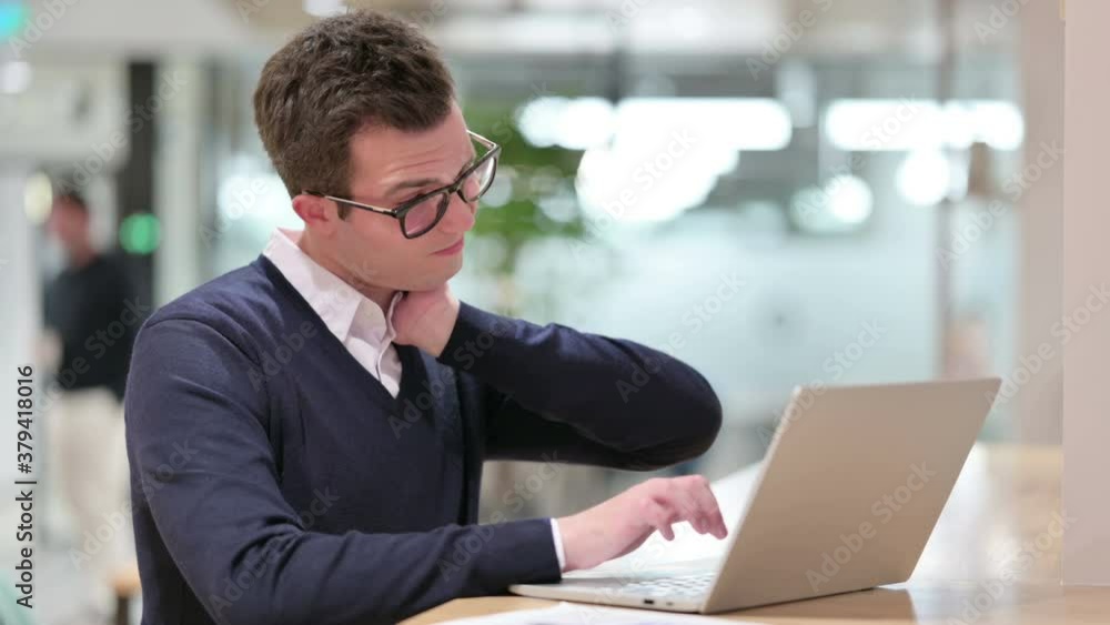 Tired Young Businessman with Laptop having Neck Pain Tired Young Businessman with Laptop having Neck Pain