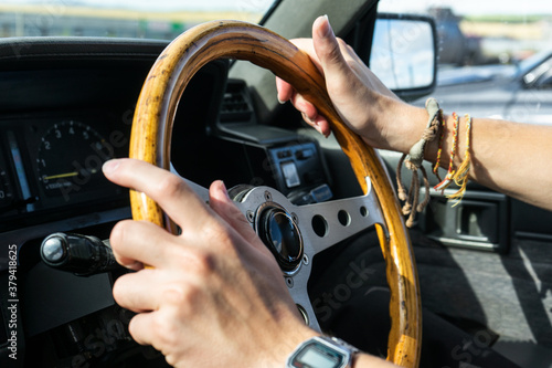 man's hands hold the steering wheel of a car.  young man driving