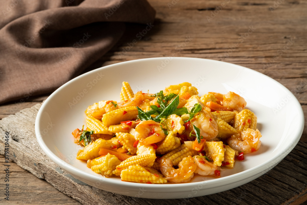 Stir fried young corn with shrimps and basil.Thai style spicy food. Stir fried young corn with shrimps and basil.Thai style spicy food.
