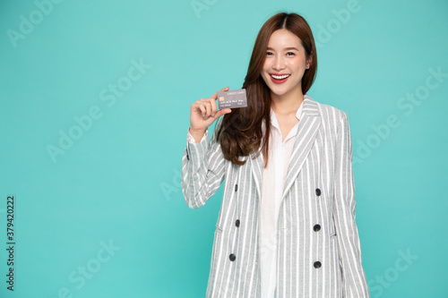 Young beautiful Asian woman smiling, showing, presenting credit card for making payment or paying online business, Pay a merchant or as a cash advance for goods, Cardholder or A person who owns a card