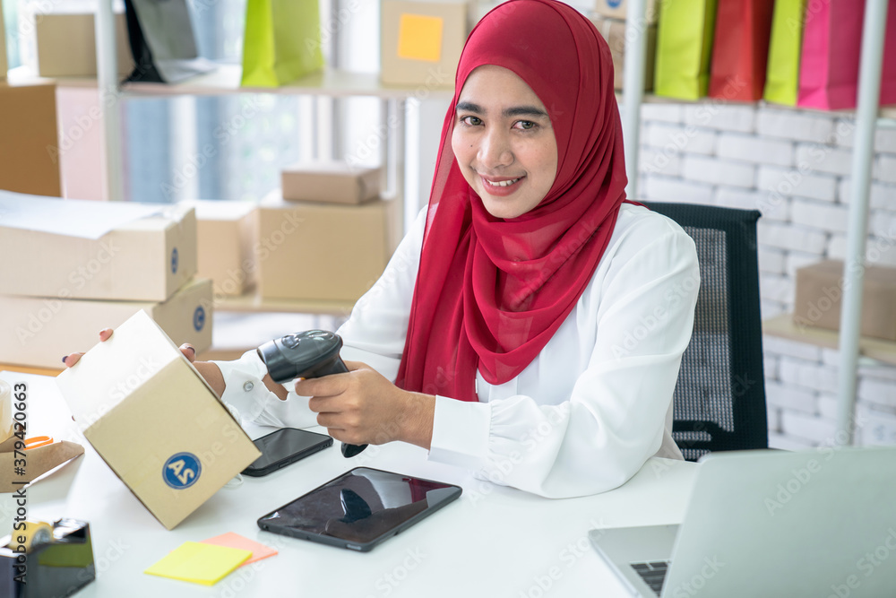 Muslim woman who owns a business, She inspects the product before sending the parcel for delivery to customers online, SME. Muslim woman who owns a business, She inspects the product before sending the parcel for delivery to customers online, SME.