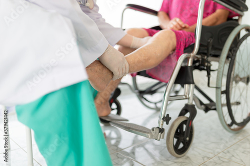 doctor holding leg of old stroke patient in hospital, elderly rehabilitation clinic, they training to rehab muscle