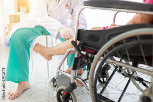 doctor holding leg of old stroke patient in hospital, elderly rehabilitation clinic, they training to rehab muscle