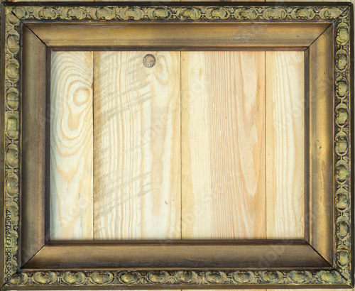 Antique gold frame with wooden background, space for inscription