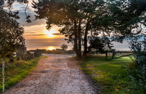 Country road leading to fishermen village, coastal landscape  at dawn, Baltic...