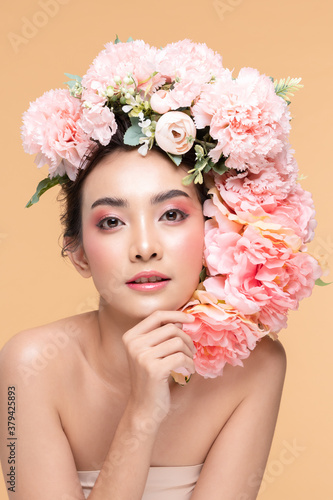 Beauty Asian young woman with big bouquet flowers on head smile with clean fresh skin Happiness and cheerful with positive emotional on Beige background Beauty Cosmetics and Facial treatment Concept