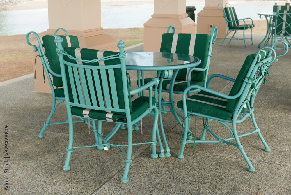A set of an empty green chair and table by the beach for hangout or discussion during leisure time