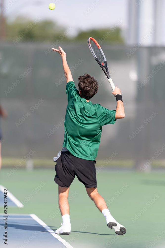 Boy serving the ball during a tennis match